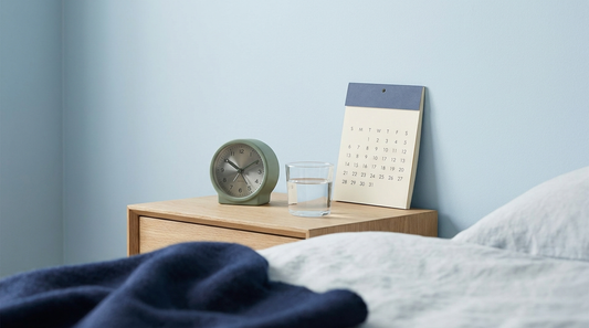 Calendar and alarm clock on a bedside table, representing how often to ejaculate for sperm health